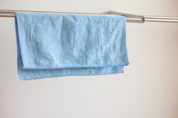 Close-up photo of a blue microfiber cloth for cleaning and drying it on the drying rack. Cloth for cleaning.