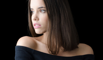 Portrait of beautiful brunette woman in black sweater isolated on black background
