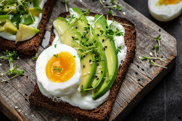 Two toasts with avocado, poached egg and microgreen. diet or vegetarian food. Top view