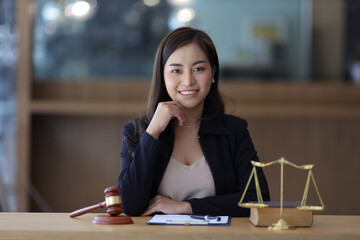 Portrait of a beautiful young woman lawyer sitting at a desk in a lawyer's office.