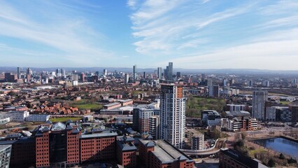 Drone image of Salford Quays with modern buildings and landmarks and views towards Manchester. 