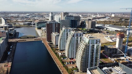 Fototapeta na wymiar Drone image of Salford Quays with modern buildings and landmarks and views towards Manchester. 