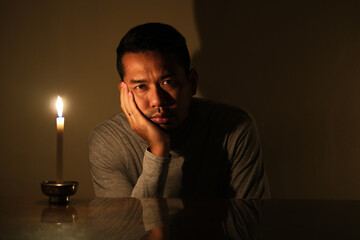 Adult Asian man showing boring expression during electricity power failure