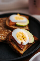 Toast with red fish, egg, avocado for breakfast. Useful snack. Recipe with boiled egg. Vegetarian menu.