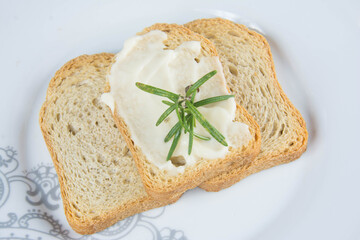 toasted inside a plate on the table with mayonnaise and rosemary