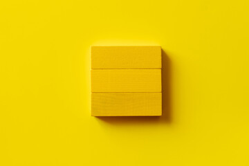 top view of square made of rectangular blocks on yellow background.