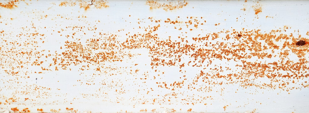 brown grainy rust texture on white metallic background with space for design. panoramic image of a metal wall with cracks, scratches and stained.
