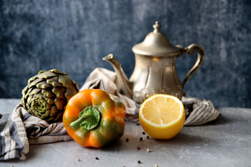 Top view photo of fresh seasonal vegetables on a table. Vibrant colors of bell pepper and two artichokes. Healthy eating concept. 
