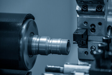 Fototapeta na wymiar The CNC lathe machine thread cutting the brass pipe connector parts.