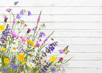Colorful meadow flowers on a white wooden background