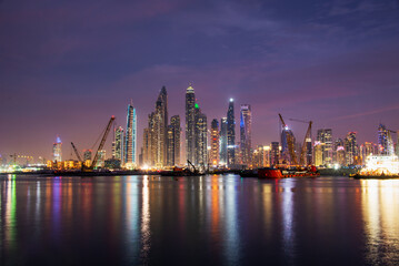 Fototapeta premium Dubai marina skyline at night with water reflections, United Arab Emirates