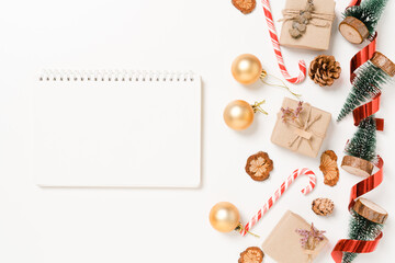 Obraz na płótnie Canvas Minimal creative flat lay of winter christmas traditional composition and new year holiday season. Top view open mockup black notebook for text on white background. Mock up and copy space photography.
