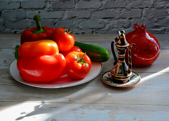 Still life with a Turkish jug, tomatoes, pepper, cucumber and a vase in the shape of a pomegranate