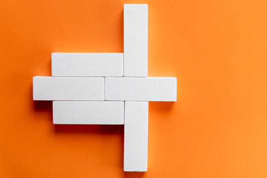 top view of white rectangular form blocks on bright orange background.