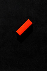 top view of bright red block on black background with copy space.