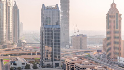 Fototapeta na wymiar Dubai city skyline panoramic view with metro and cars moving on city's busiest highway aerial timelapse
