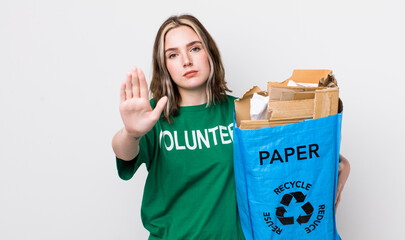 pretty caucasian woman looking serious showing open palm making stop gesture. ecology concept