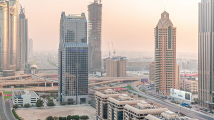 Dubai city skyline panoramic view with metro and cars moving on city's busiest highway aerial timelapse