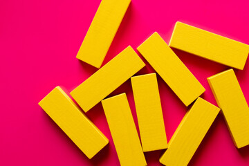 top view of several yellow blocks on bright pink background.