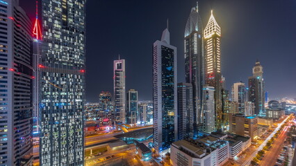 Fototapeta premium Aerial view of Dubai International Financial District with many skyscrapers all night timelapse.