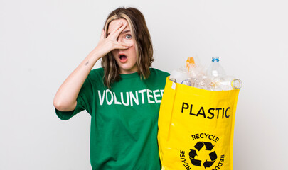 pretty caucasian woman looking shocked, scared or terrified, covering face with hand. ecology...
