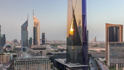 Obraz premium Aerial view of Dubai International Financial District with many skyscrapers day to night timelapse.