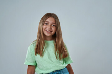 Obraz premium Smiling little girl posing and looking at camera
