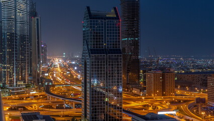 Fototapeta na wymiar Dubai city skyline panoramic view with metro and cars moving on city's busiest highway aerial night to day timelapse