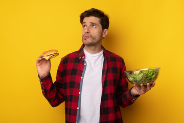 Portrait of Funny Guy Holding Burger And Salad