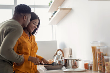Portrait Of Romantic Young African American Couple Cooking Together In Kitchen
