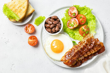 Full English breakfast with baked beans on plate. Top view, copy space.