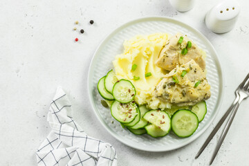 Mashed potatoes, cucumber salad, creamy sauce chicken. Top view, copy space.