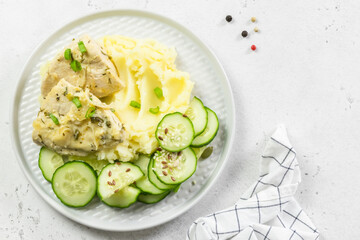 Mashed potatoes, cucumber salad, creamy sauce chicken. Top view, copy space.