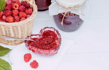Homemade healthy jam with raspberries on a white wooden table. Treatment of colds. Conservation and summer harvesting.