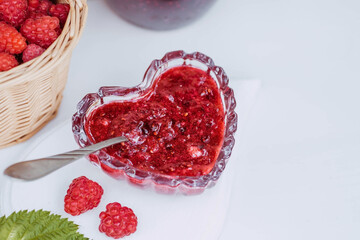 Homemade healthy jam with raspberries on a white wooden table. Treatment of colds. Conservation and summer harvesting.
