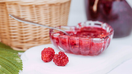 Homemade healthy jam with raspberries on a white wooden table. Treatment of colds. Conservation and summer harvesting.
