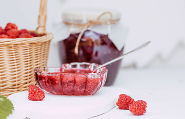 Homemade healthy jam with raspberries on a white wooden table. Treatment of colds. Conservation and summer harvesting.