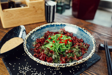 wakame seaweed salad with walnut sauce and sesame seeds in a plate