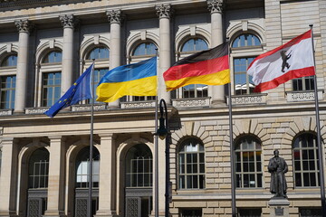 Das Berliner Abgeordnetenhaus mit den wehenden Fahnen von Berlin, Deutschland, der Ukraine und der...