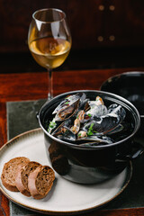 Mussels in a creamy sauce with parsley, baguette and white wine.