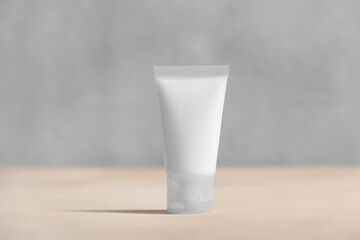 Cosmetics tube mockup. Blank cream tube on minimalistic pastel background