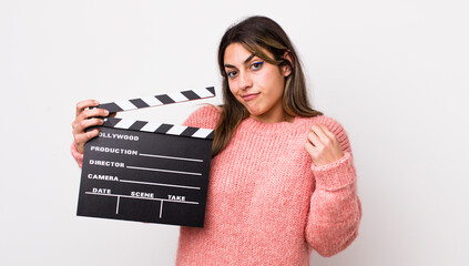 pretty hispanic woman looking arrogant, successful, positive and proud. cinema clapper concept