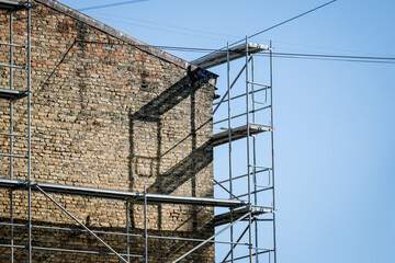 Reconstruction of an old brick house. Scaffolding for construction, construction site. Selective focus