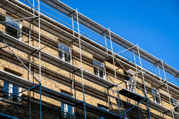 Reconstruction of an old brick house. Scaffolding for construction, construction site. Selective focus