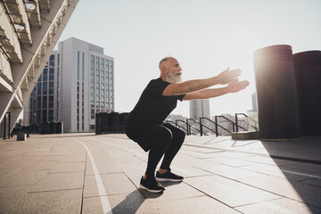 Photo of pretty confident retired man black sportswear doing sitting up exercises outside urban...