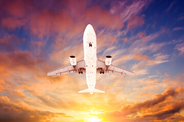 Fototapeta na wymiar Airplane flying overhead during a black sunset.