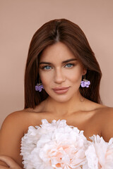Pretty woman with bright makeup. Beautiful white girl with flowers. Stunning brunette girl with big bouquet of peonies. Closeup face of young beautiful woman with a healthy clean skin.