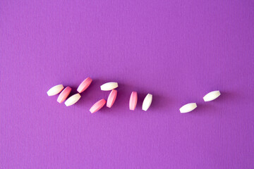 Vitamin tablets on a violet background. Dietary supplements and pills for dieting. Medical concept....