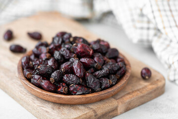 dried berries of large wild rose in a wooden bowl