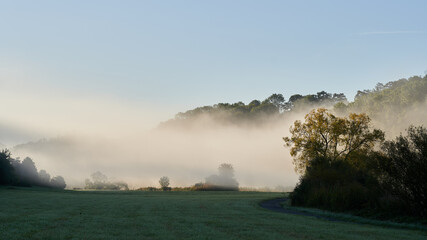 Nebelschwaden ziehen an einem sonnigen Herbstmorgen &uuml;ber das Lahntal
